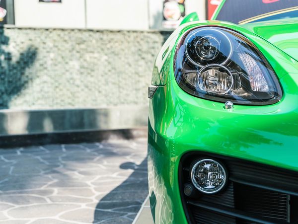 Gros plan sur le phare d'une voiture verte brillante.