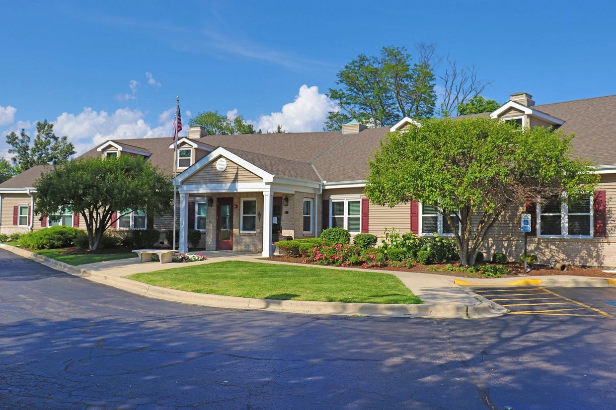 Single-story residential building with landscaping and clear skies.