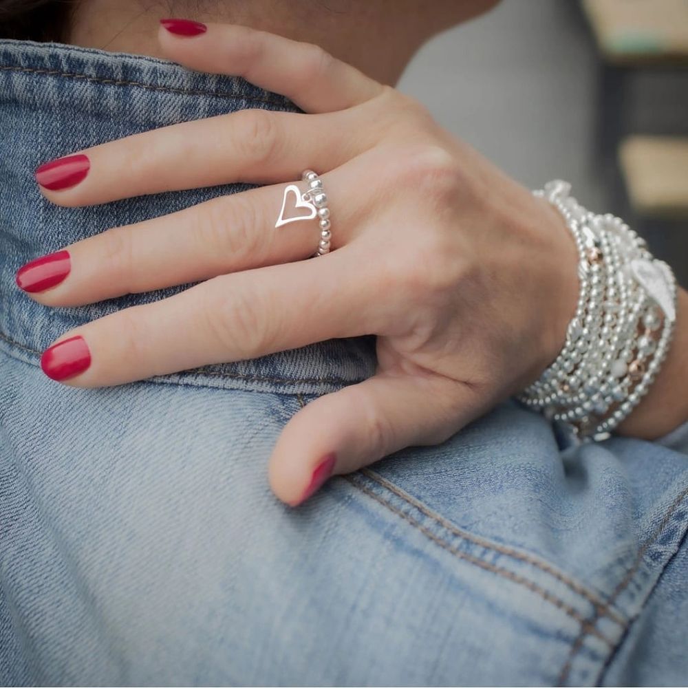 woman's hand with crafted bracelets and ring