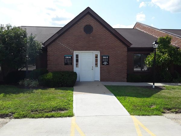 Brick building with double white doors and signs on each side.