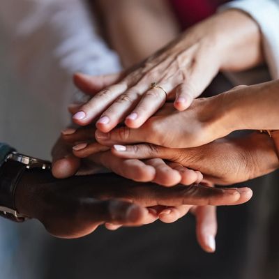 Many hands laid on top of each other offering group support