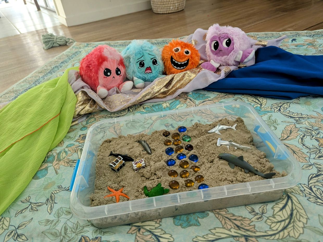 Sand tray and emotion balls set up as they may be in a mobile play therapy sessions.