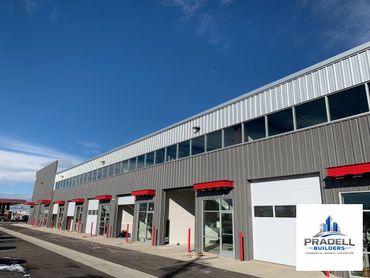 Modern commercial building with red accents under a clear blue sky.