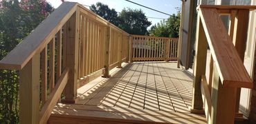 Entryway with handrails going onto pressure treated deck.