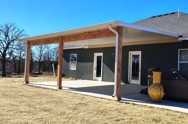 Insulated patio cover in white with cedar posts and beams.
