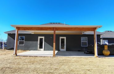 Insulated patio cover in white with cedar posts and beams.