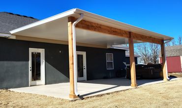 Insulated patio cover in white with cedar posts and beams.