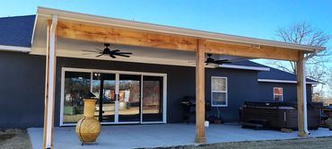 White insulated patio cover with dual fan installation and cedar posts and beams.