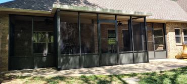 An aluminum screen patio enclosure in bronze with kick panels at the bottom.