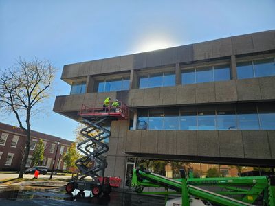 Two employees pressure washing building in Winnetka, IL.