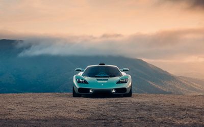 Sports car on a mountain road at sunset.