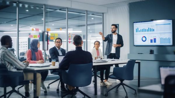 Team in a meeting reviewing data on a large screen.