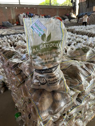 A sack of potatoes labeled Al Batoul stacked in a warehouse.