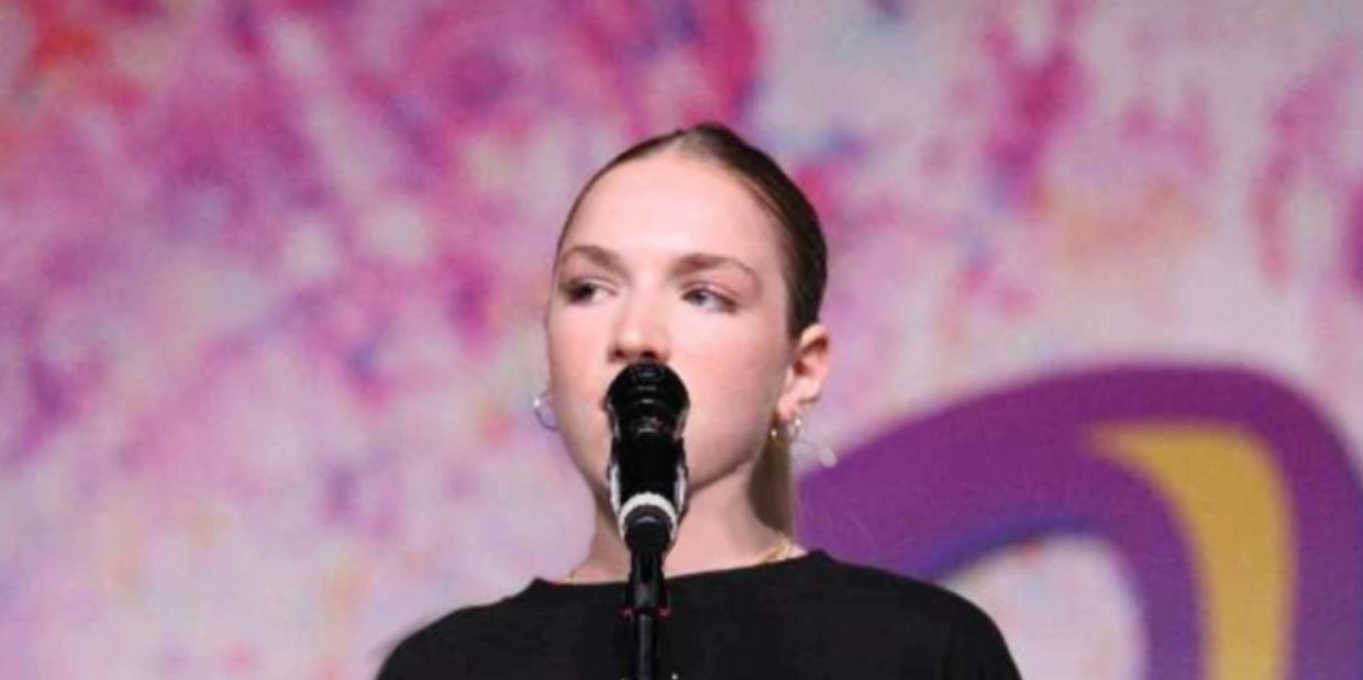 Person speaking or singing into a microphone.