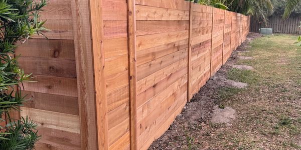 A long wooden fence along a yard.