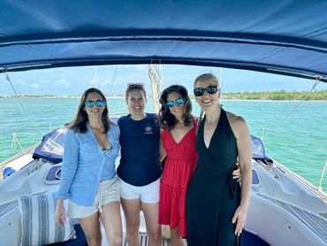 Four lovely ladies enjoying a private  sailing charter to celebrate a birthday with Boot Key behind.