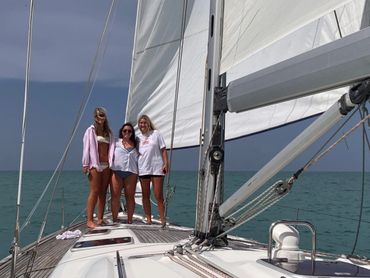 Emily Seele,Mally Nappier, & Campbell Guthrie on a sailing charter standing on the bow of Chao Lay.