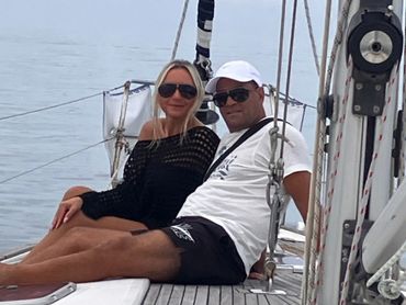 Husband and wife enjoying a sailboat tour seated on the foredeck of Chao Lay in Marathon, FL.