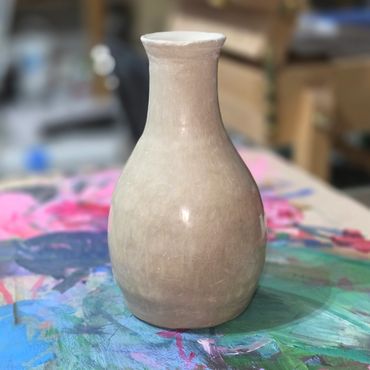 Handcrafted ceramic vase on vibrant surface.