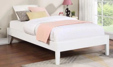 A white wooden single bed with pillows and a pink throw blanket in a bright room.