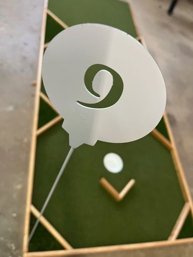 Cornhole board with a white numbered marker and wooden bean bags.