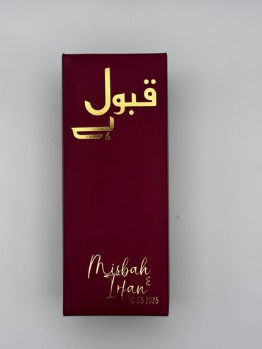 Elegant maroon box with golden Arabic text and names Misbah & Irfan with a date.