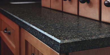Close-up of a kitchen countertop with wooden drawers and metal handles.