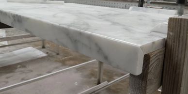 Polished marble slab secured on wooden supports in a workshop.