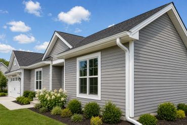 Modern gray house with white trim and well-kept landscaping.