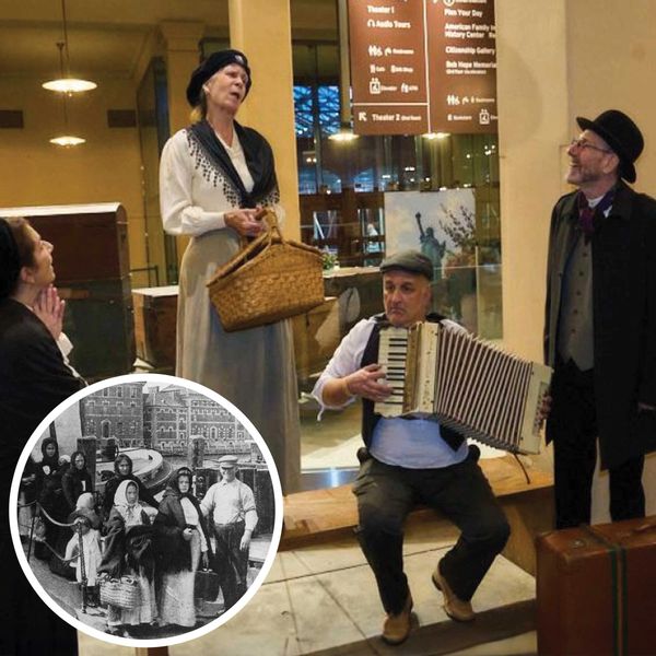 A photo showing actors dressed as immigrants passing through Ellis Island back in the day.