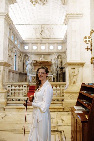 Clarissa Pollack playing solo violin for a wedding in a church
