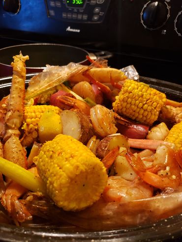 A close-up of a shrimp and crab boil with corn and potatoes.