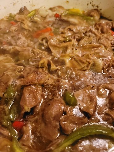 Close-up of a simmering stew with meat and vegetables.