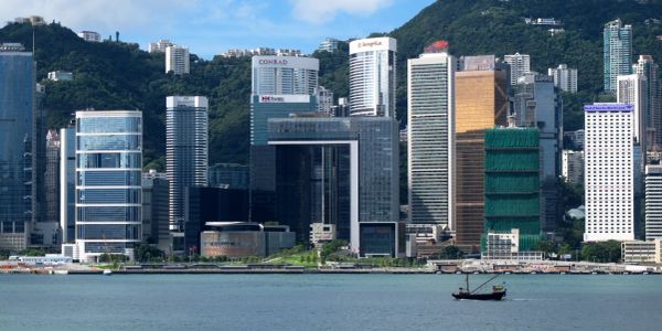 City skyline with high-rise buildings and a boat on the water.