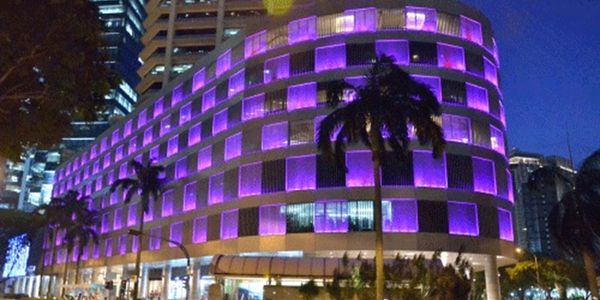 Modern building illuminated with purple lights at night.