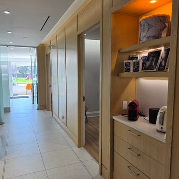 Modern hallway with wooden paneling and a small coffee station.