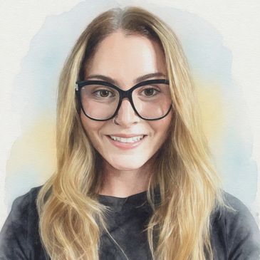Young woman with long blonde hair and black glasses smiling.