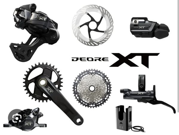 Shimano Deore XT bike components set including derailleur, crank, disc brake, and shifter.