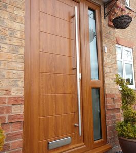 Golden Oak Solid Core front door with mid rail side panel and long bar handle fitted in Linby.