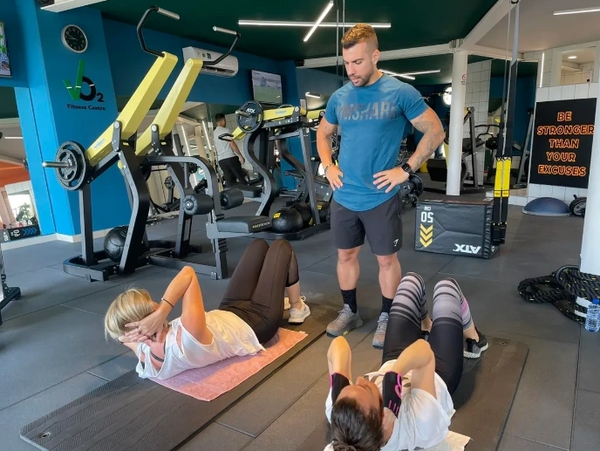 Personal trainer doing a group personal training session, abdominal exercises