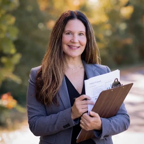 Professional woman holding a clipboard with documents outdoors.