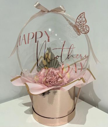 Mother's day pink bubble balloon with florals inside. Finished with ribbon and pink butterfly decor.