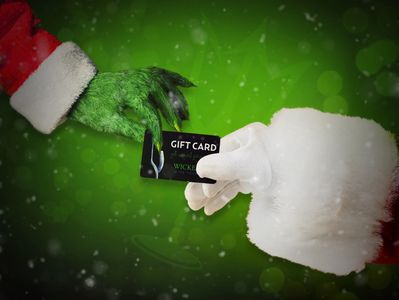 The Grinch hands Santa Wicked Wine Tours gift card