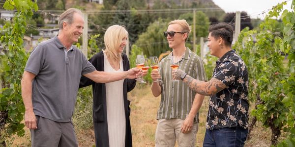 Group of people drinking wine in a vineyard