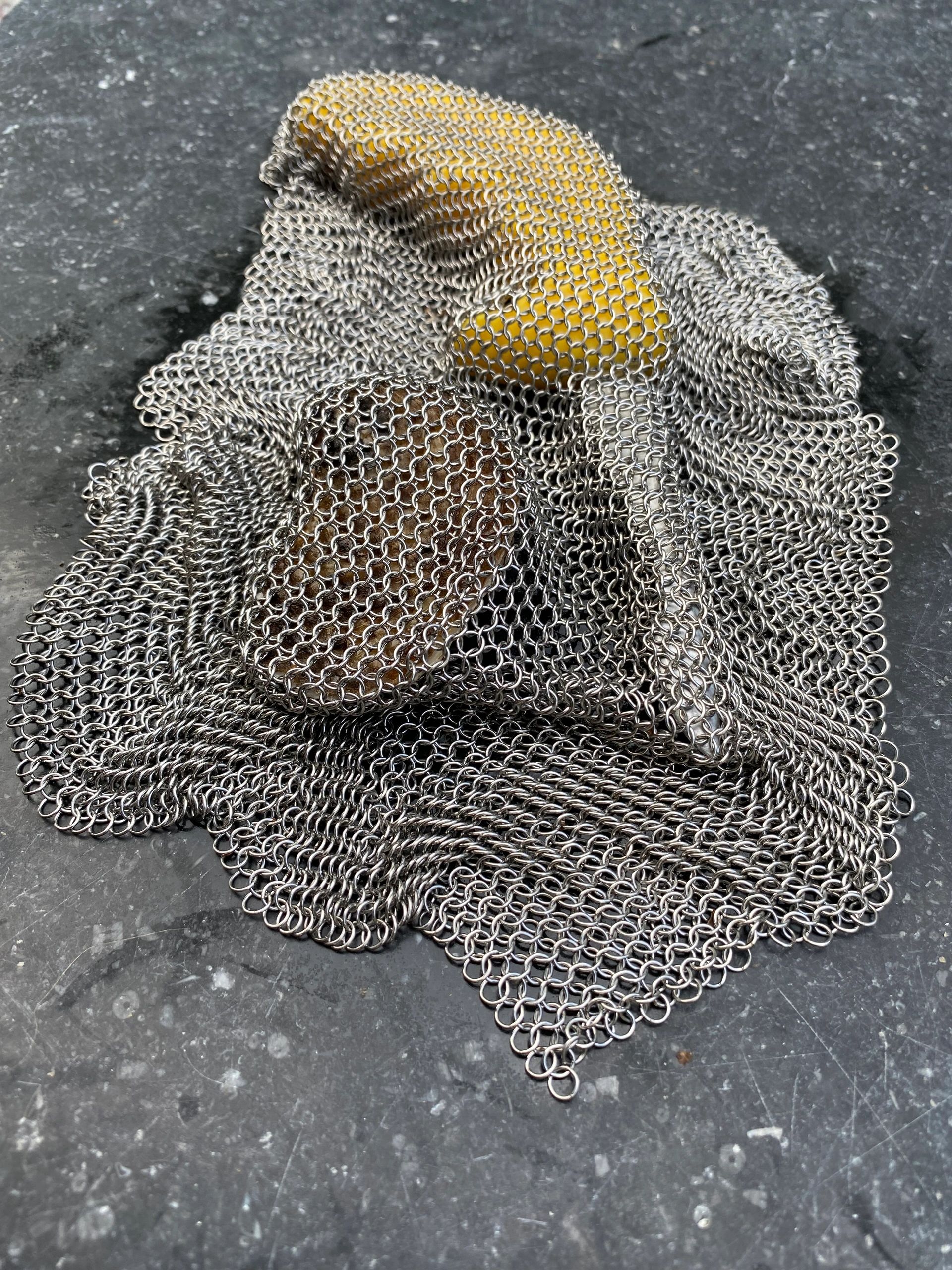 Chainmail fabric over rocks on a stone surface.