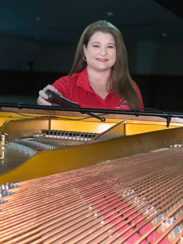 Madilene Loosier Tuning grand piano at a church