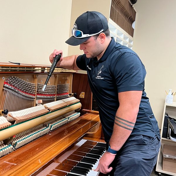 Brandon Loosier tuning an upright church piano