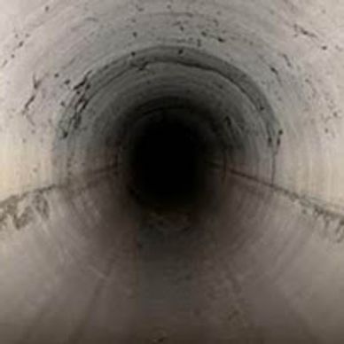 Dark underground tunnel with curved walls.
