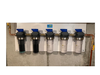 A row of five water filtration units mounted on a wall with blue valves.
