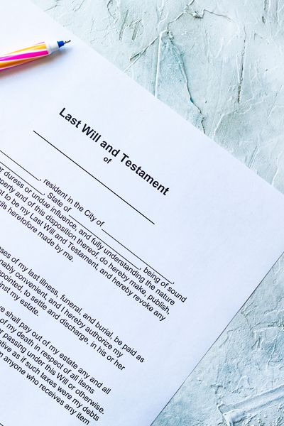 A partially visible "Last Will and Testament" document with a colorful pen.